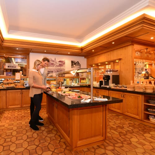 Paar bedient sich am Buffet in einem holzverkleideten Restaurant.