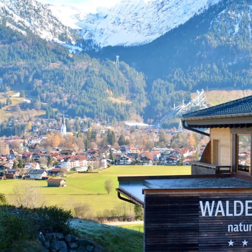 Außenansicht des Waldruhe Naturhotels mit Berglandschaft