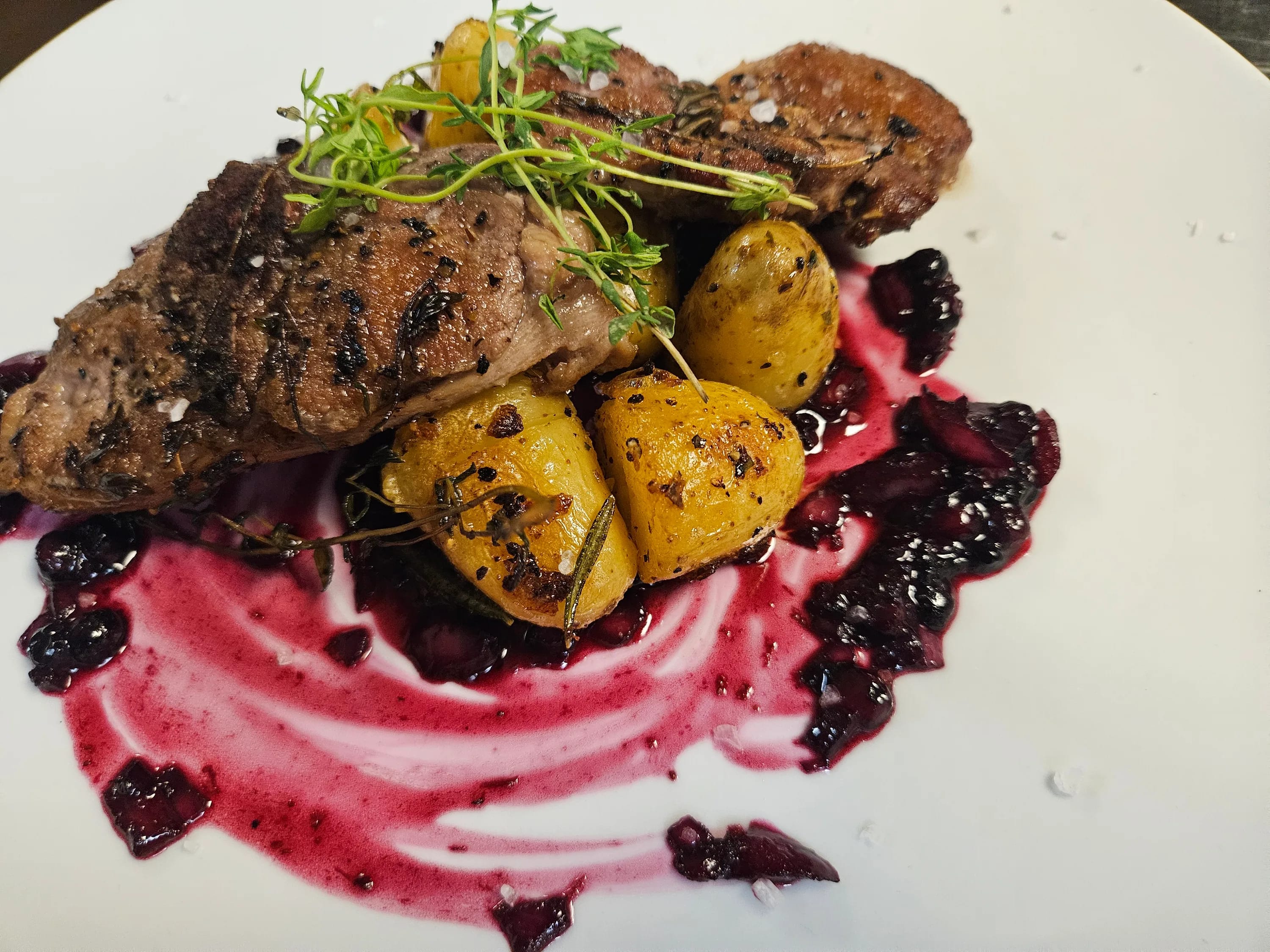 Gegrilltes Steak mit Ofenkartoffeln, Kräutern und pinkfarbener Sauce